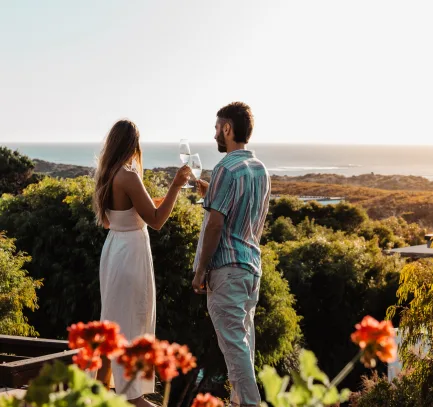 Couple toasting during a South West weekend getaway, staying at a Margaret River holiday home managed by Swell Stays with premium rentals and accommodation.