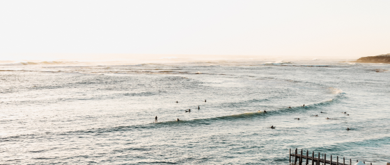 Gnarabup Beach with the jetty and surfers in the water. Swell Stays holiday accommodation image in Margaret River