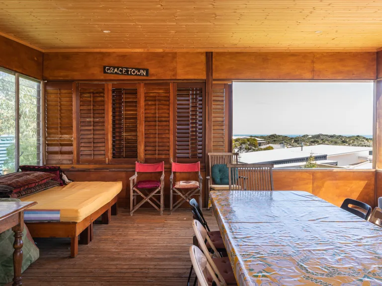 Outdoor room with a day bed and dining table, with ocean views.